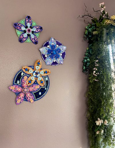 Flower sculpture grouping on a wall with decor items